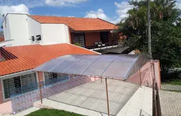 Toldo para garagem protegendo veículos em residência em Curitiba