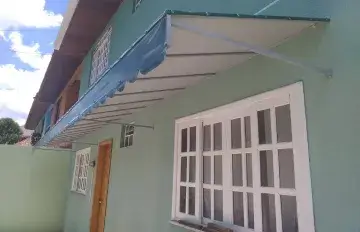 Toldo instalado sobre janelas de casa em Curitiba
